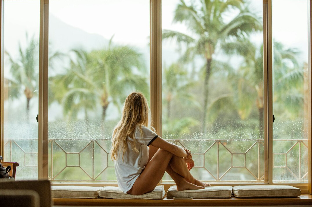 Person sitting calmly by a window reflecting
