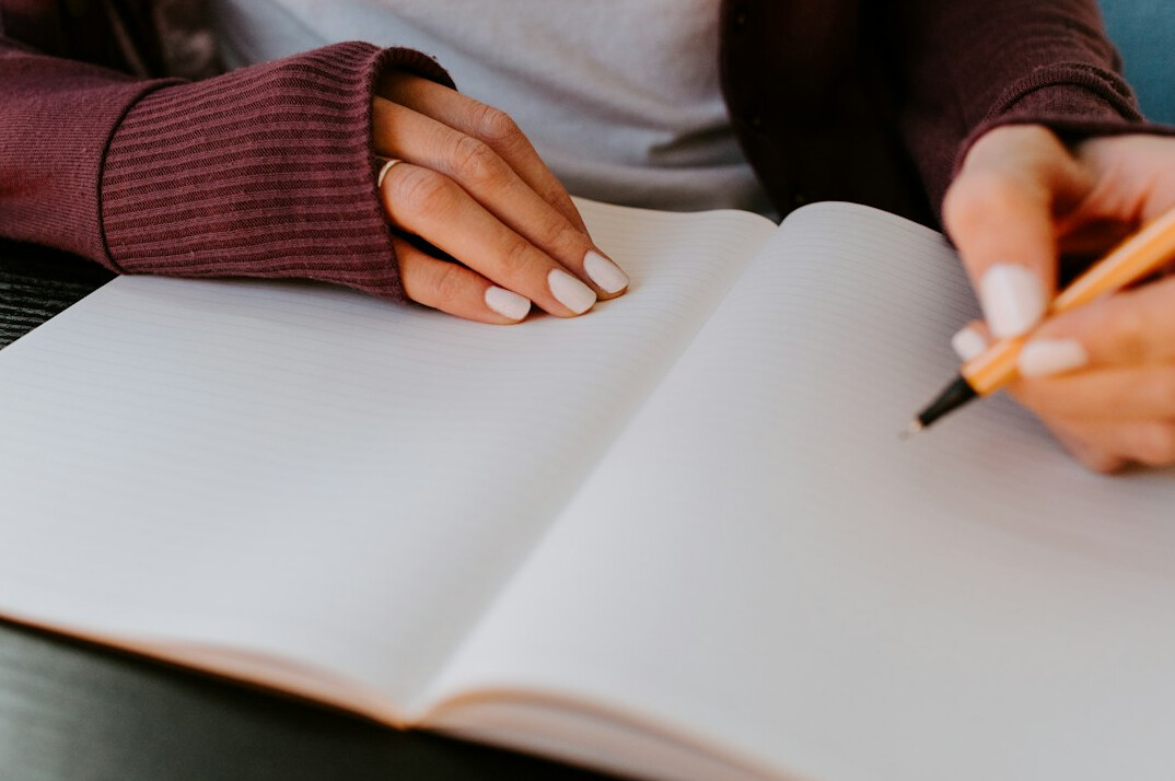person writing in journal