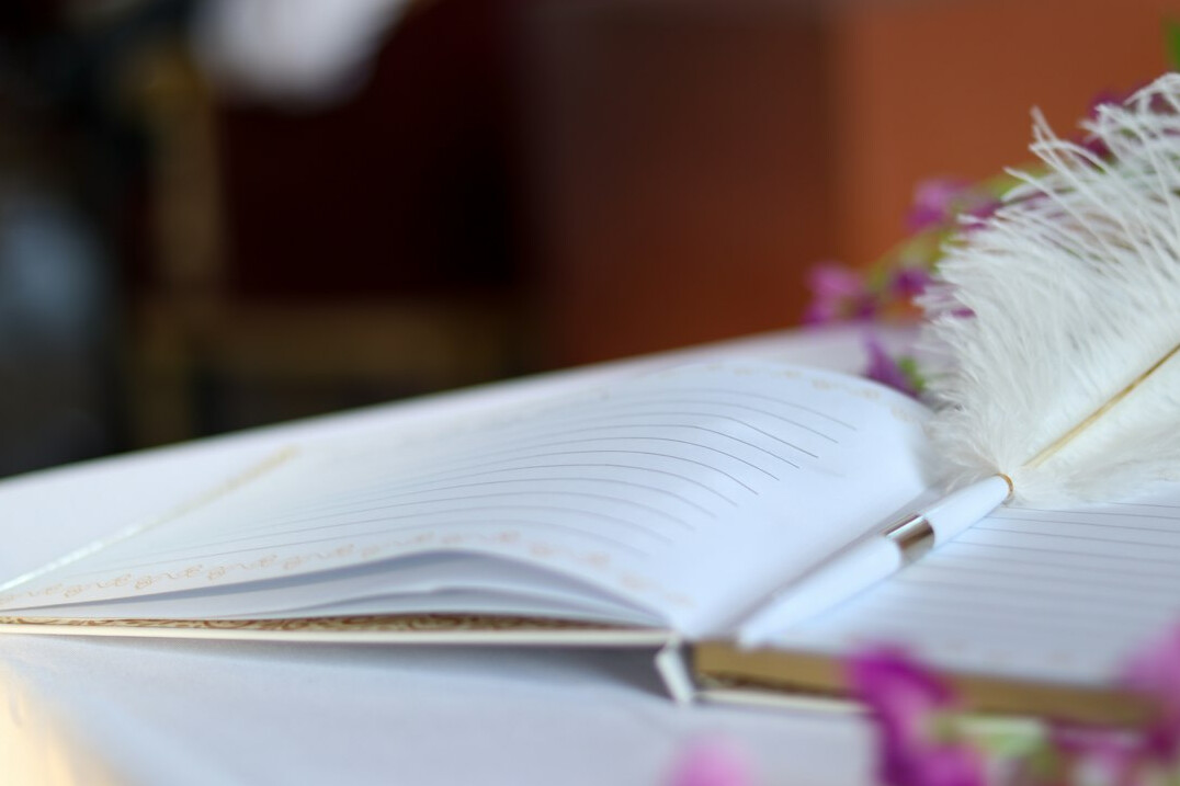 Open notebook with handwriting and a pen on a table